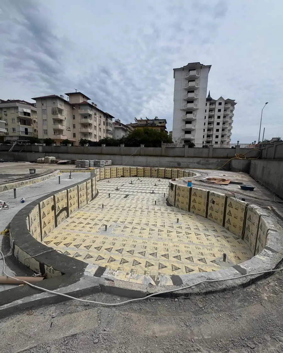 Oval betonarme havuzun taban ve duvarlarına serilen sarı yalıtım levhaları, şehir içinde süren şantiye