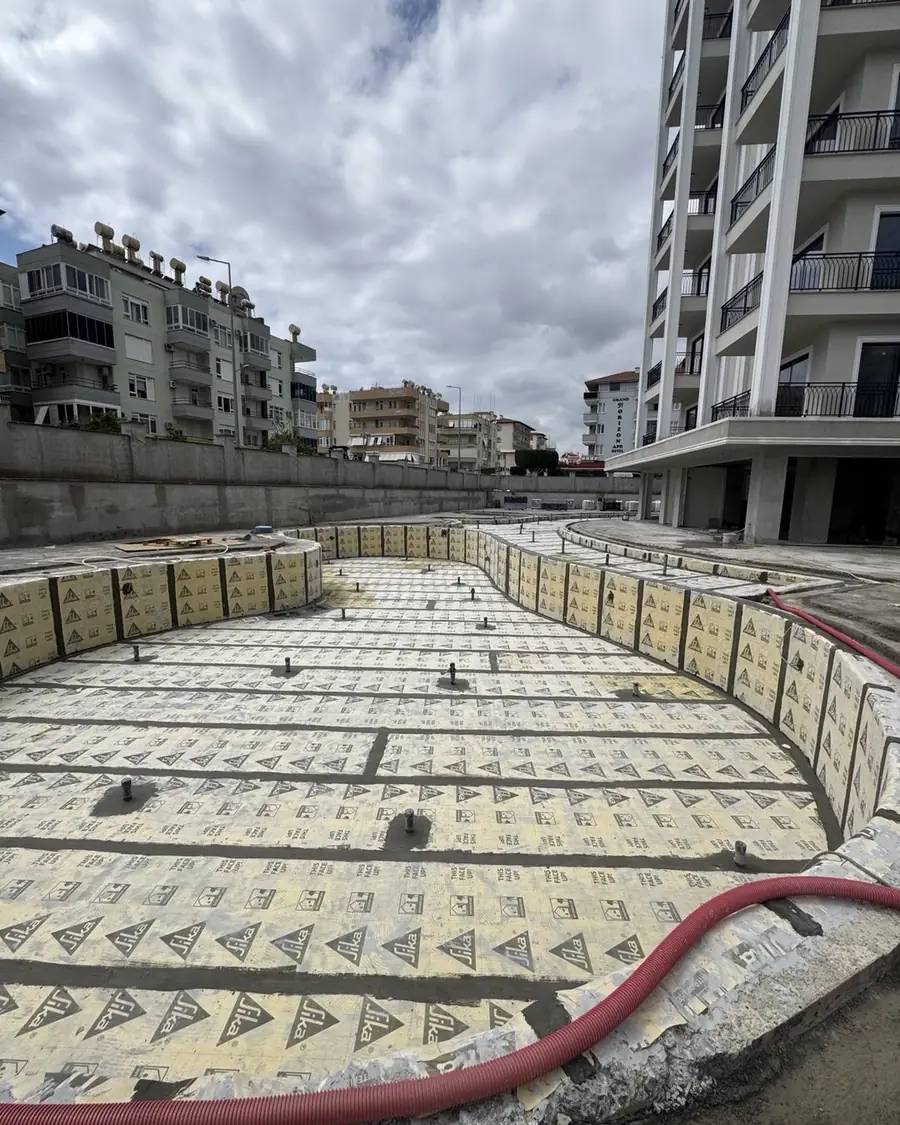 Apartmanlar arasındaki boş havuzun taban ve duvarlarını kaplayan yalıtım levhaları, kaplama öncesi aşama