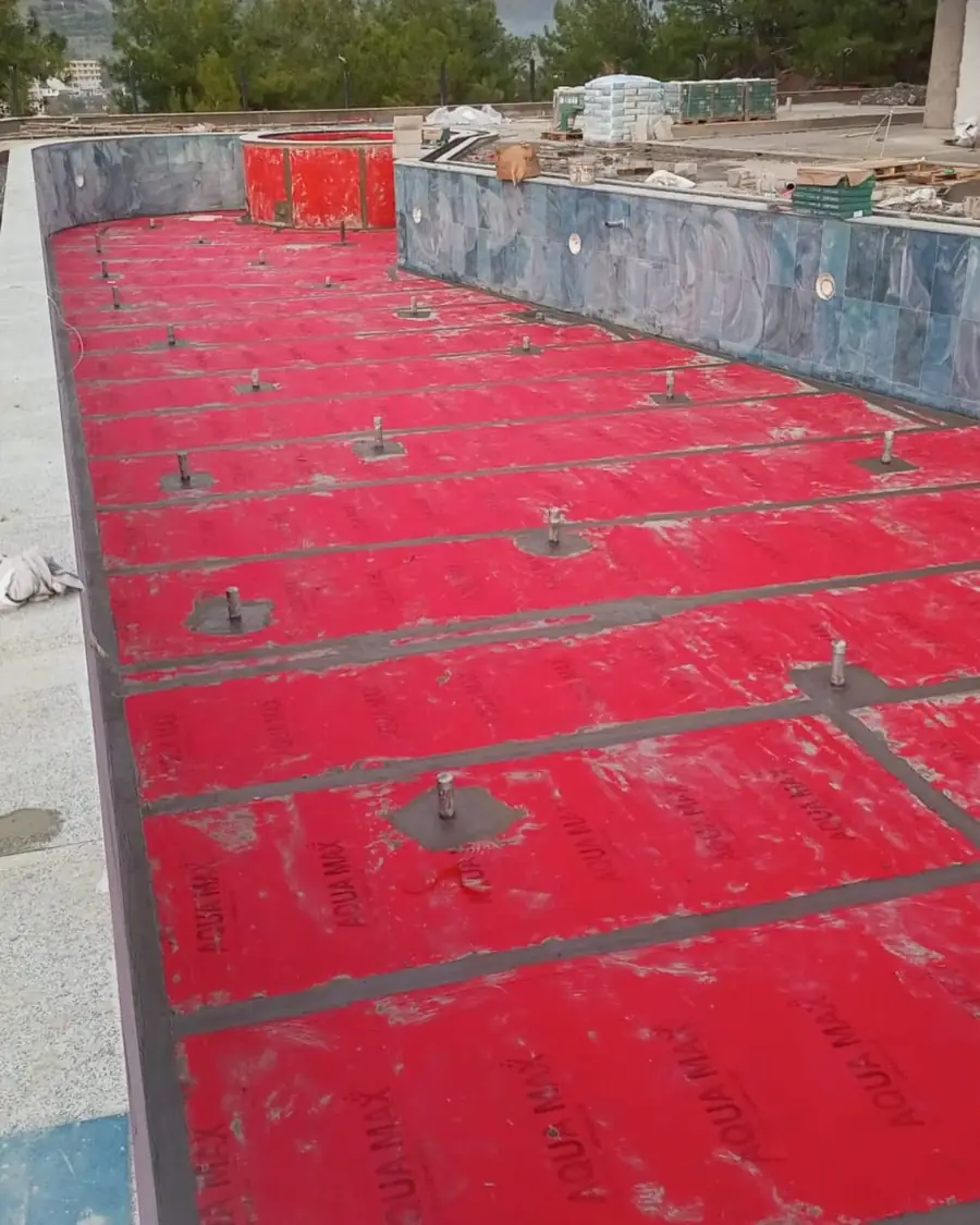 Havuz tabanına döşenen kırmızı yalıtım levhaları, ankraj plakalari ve mavi seramik kaplı havuz duvarları