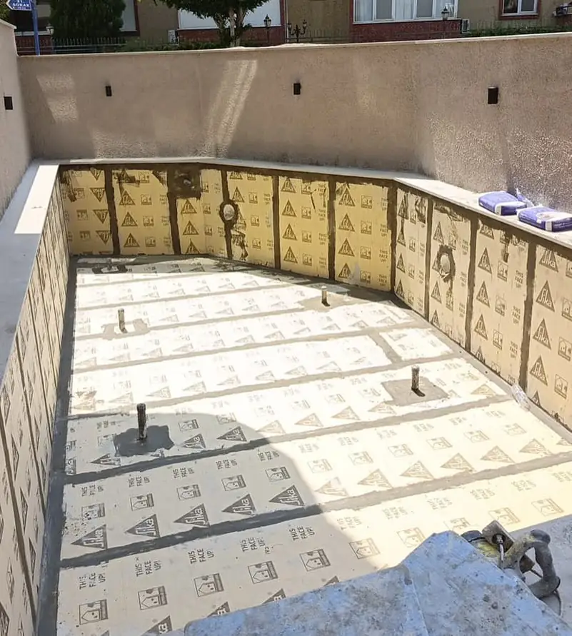 Bahçe duvarıyla çevrili havuz teknesinde duvar ve taban levhalarının derzleri harçla kapatılmış