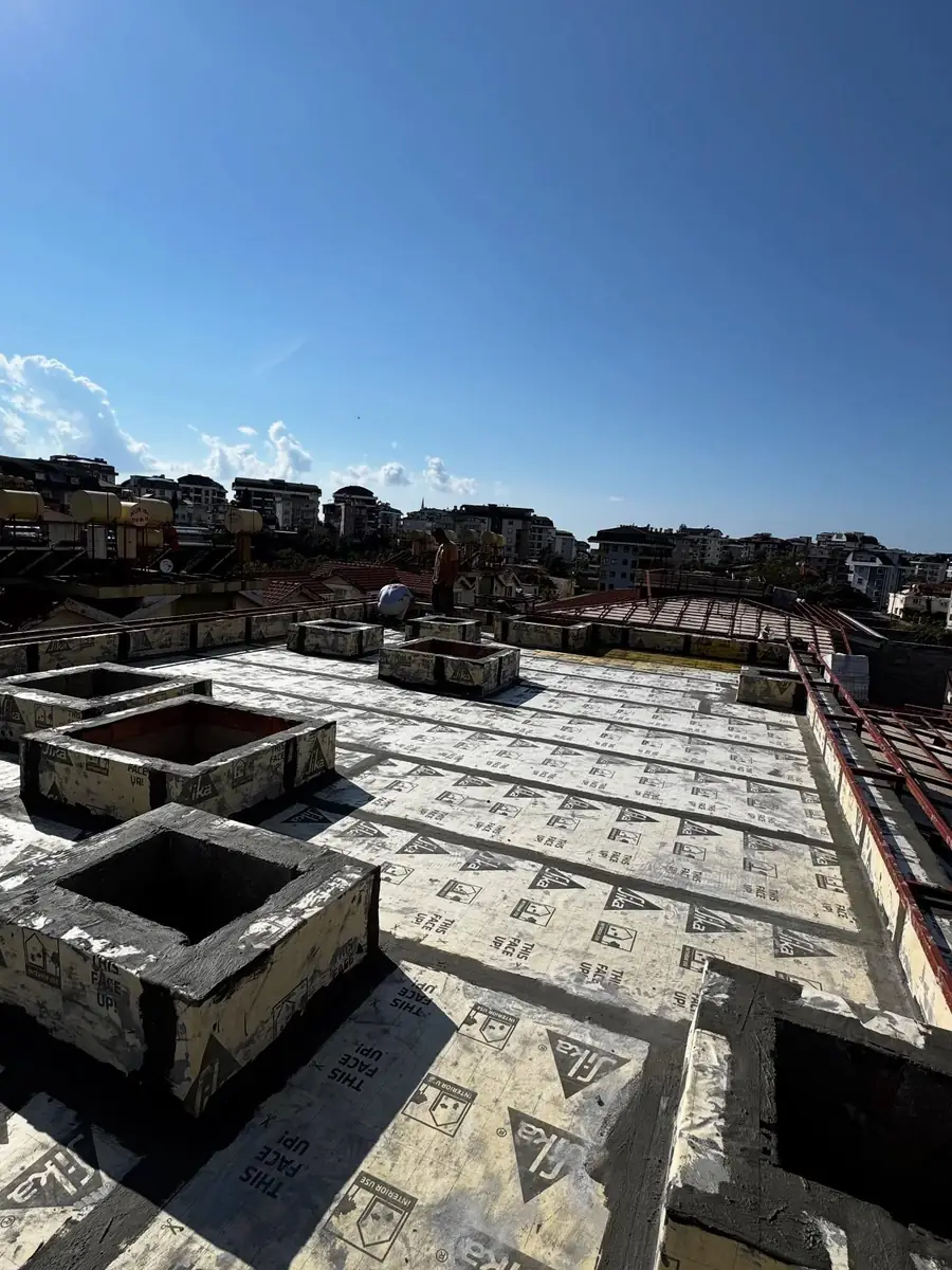 Çatı döşemesini kaplayan Sika yalıtım levhaları ve levhalarla sarılmış baca kaideleri